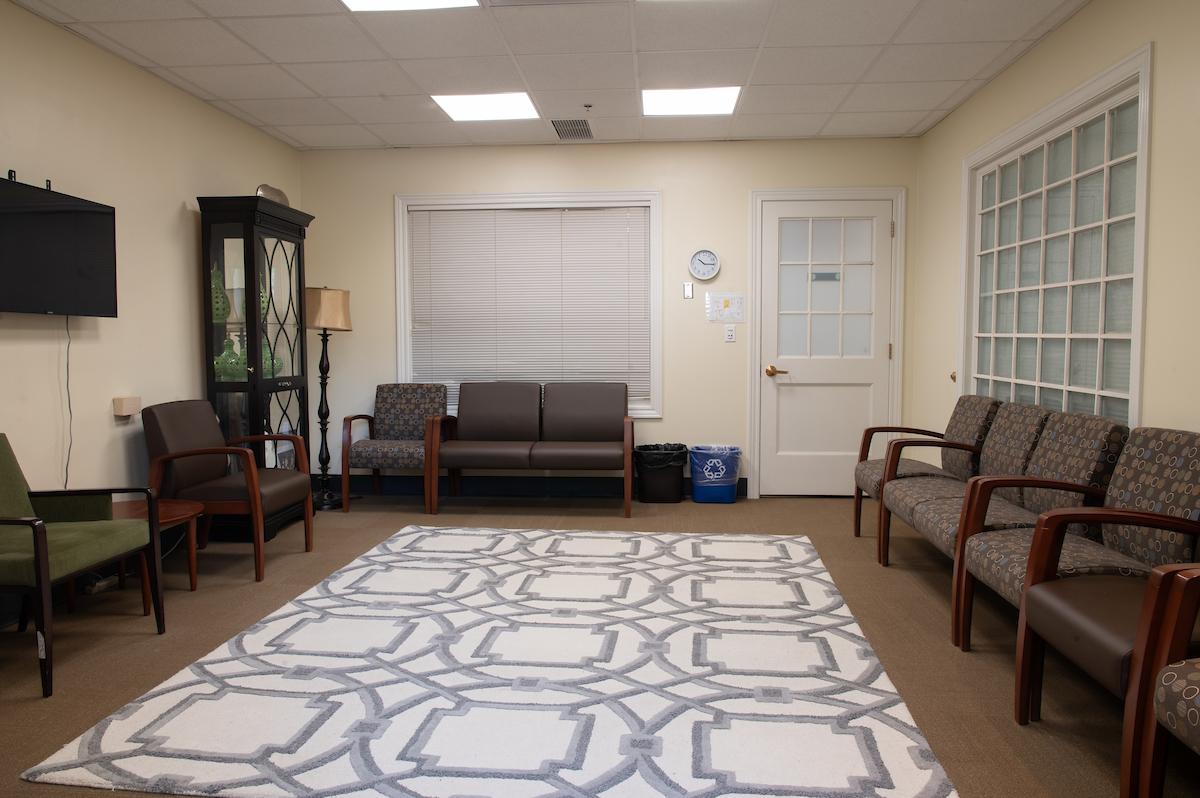 林德利大厅的集体治疗室里有几把深色椅子和白灰相间的地毯