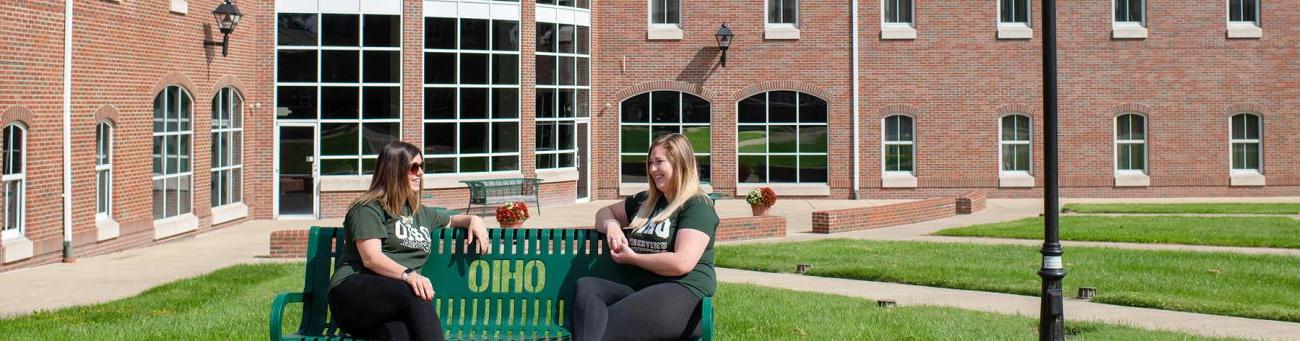 Two OHIO Southern students sitting on a bench on the Southern campus