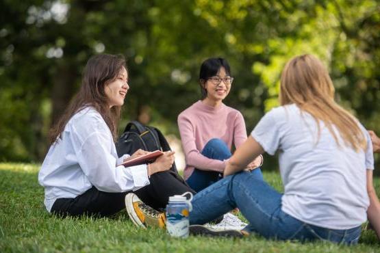 Three international students talking on College Green